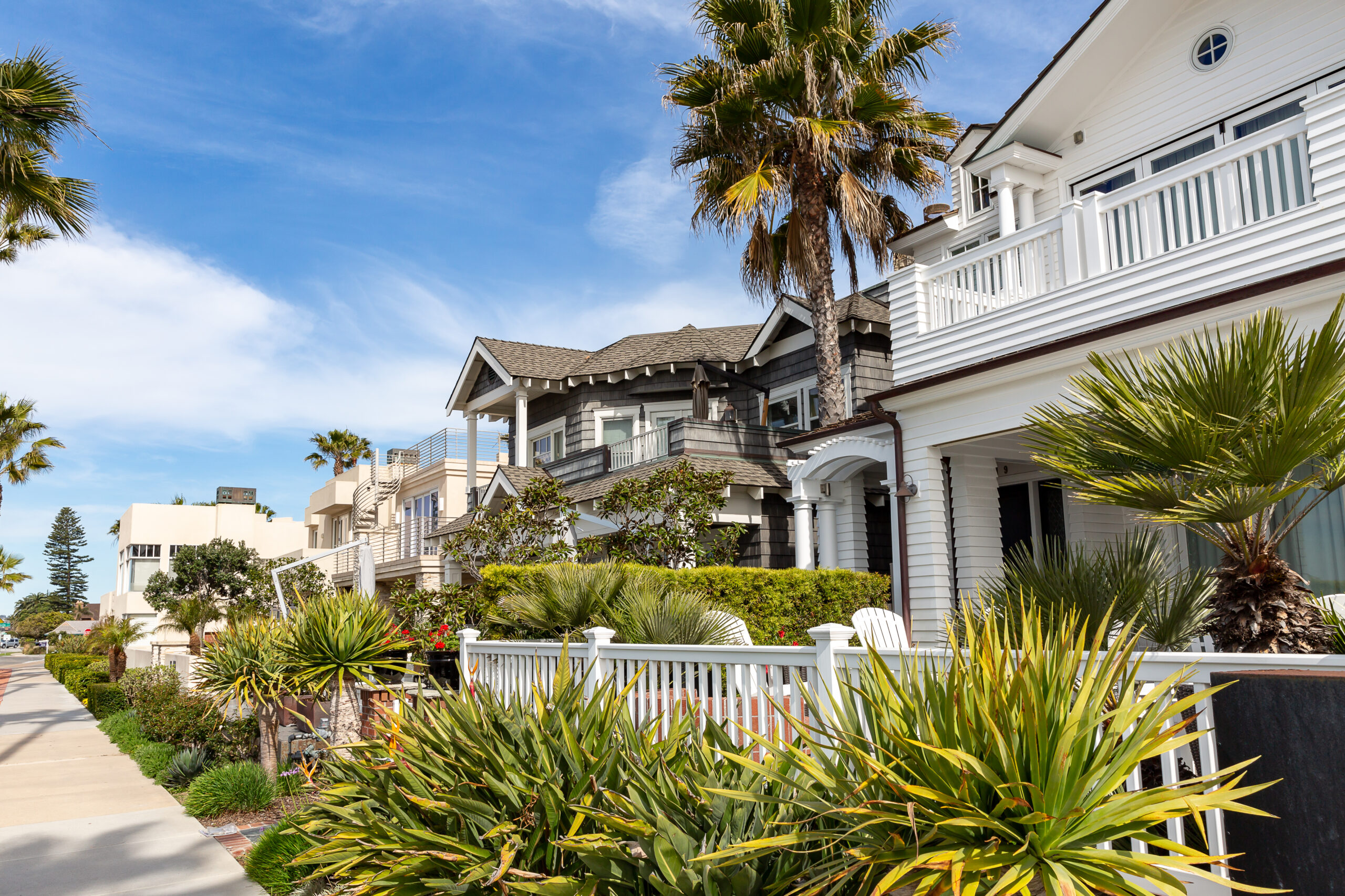 Coronado street lined with historic Craftsman and Spanish Revival homes under palm trees
